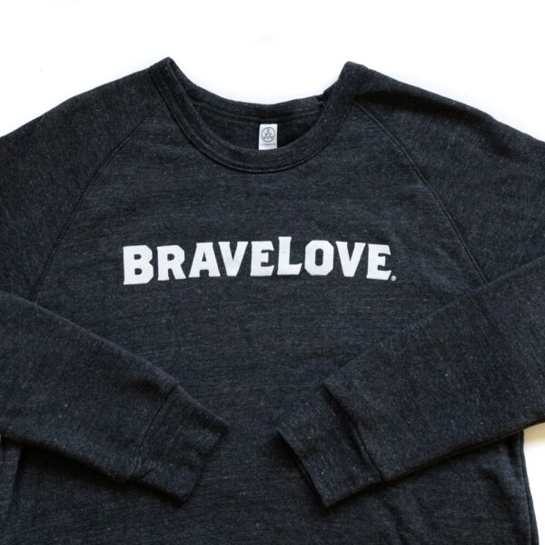 A charcoal grey sweatshirt with the word "BRAVELOVE." printed in white letters across the chest, with sleeves spread out on both sides.