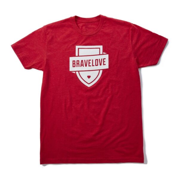 Product Data: Red T-Shirt with "BRAVELOVE" printed in white across a shield design and a small heart at the bottom.

Rewrite: This Red T-Shirt features the word "BRAVELOVE" printed in white on a shield design, accented with a small heart at the bottom.