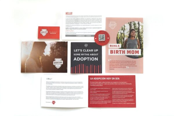 The Starter Resource Kit, featuring a variety of printed materials and cards about adoption such as brochures, postcards, and a QR code sign, displayed on a white surface.