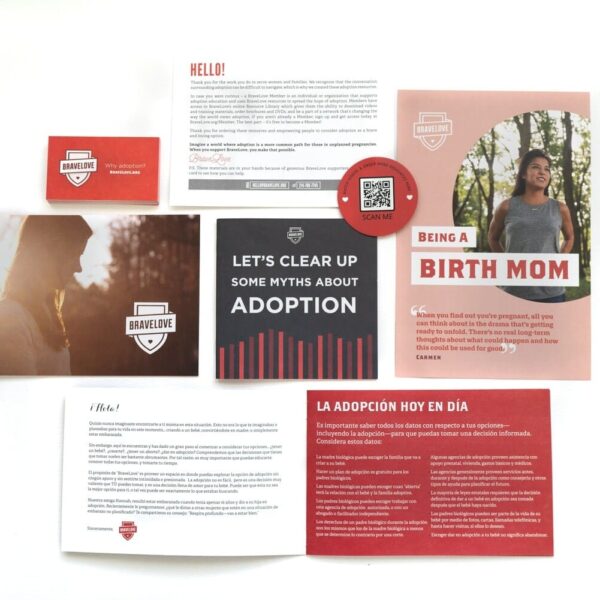 The Starter Resource Kit, featuring a variety of printed materials and cards about adoption such as brochures, postcards, and a QR code sign, displayed on a white surface.