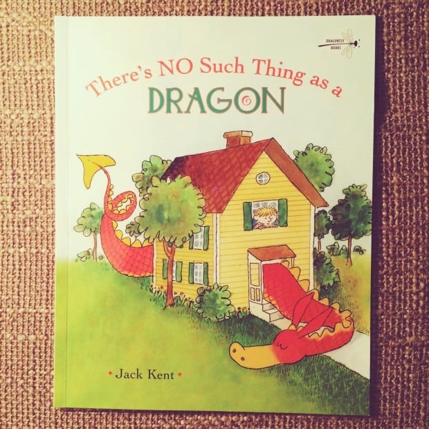 A book cover of "There's No Such Thing as a Dragon" by Jack Kent, showing a dragon wrapping around and peering into a yellow house.